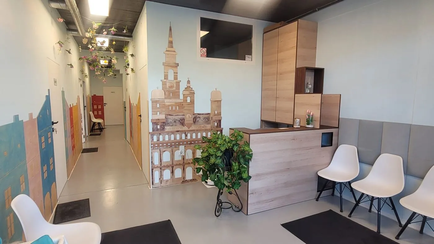 Jasna poczekalnia z recepcją i krzesłami